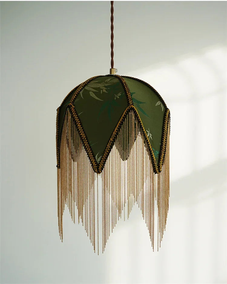 Close-up of a green fabric pendant light with gold chain fringe.