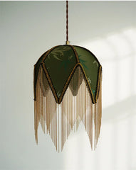 Close-up of a green fabric pendant light with gold chain fringe.