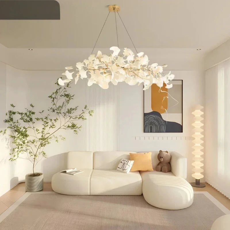 Close-up of a white ceramic ginkgo leaf shade on a gold branch of the pendant light