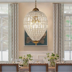Crystal chandelier hanging above a dining table with decorative elements.