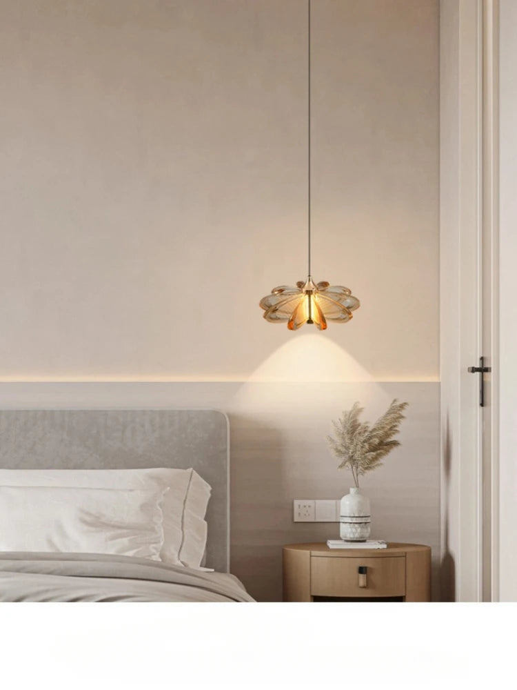 Modern bedroom with a pendant light fixture, bed, and side table.
