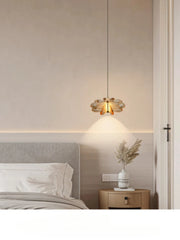 Modern bedroom with a pendant light fixture, bed, and side table.