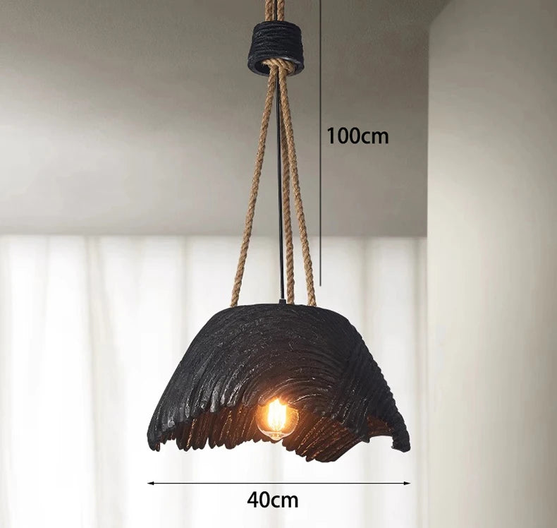 Black pendant light with rustic design, hanging from a rope, against a neutral background.