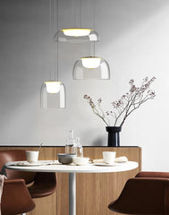 Modern dining area with round table, chairs, and pendant lights.