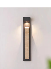 A modern black wall sconce with a natural stone insert, lit from above and below casting light patterns.