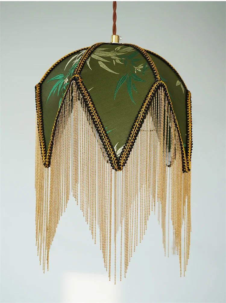 Close-up of the top of a green fabric pendant light showing the fringed edge detail.