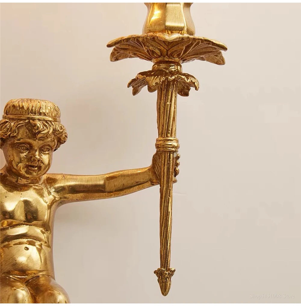 Gold cherub figurine holding a sword against a beige background