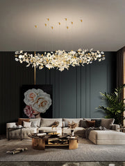 Modern living room with a large chandelier, gray sofa, and decorative elements.