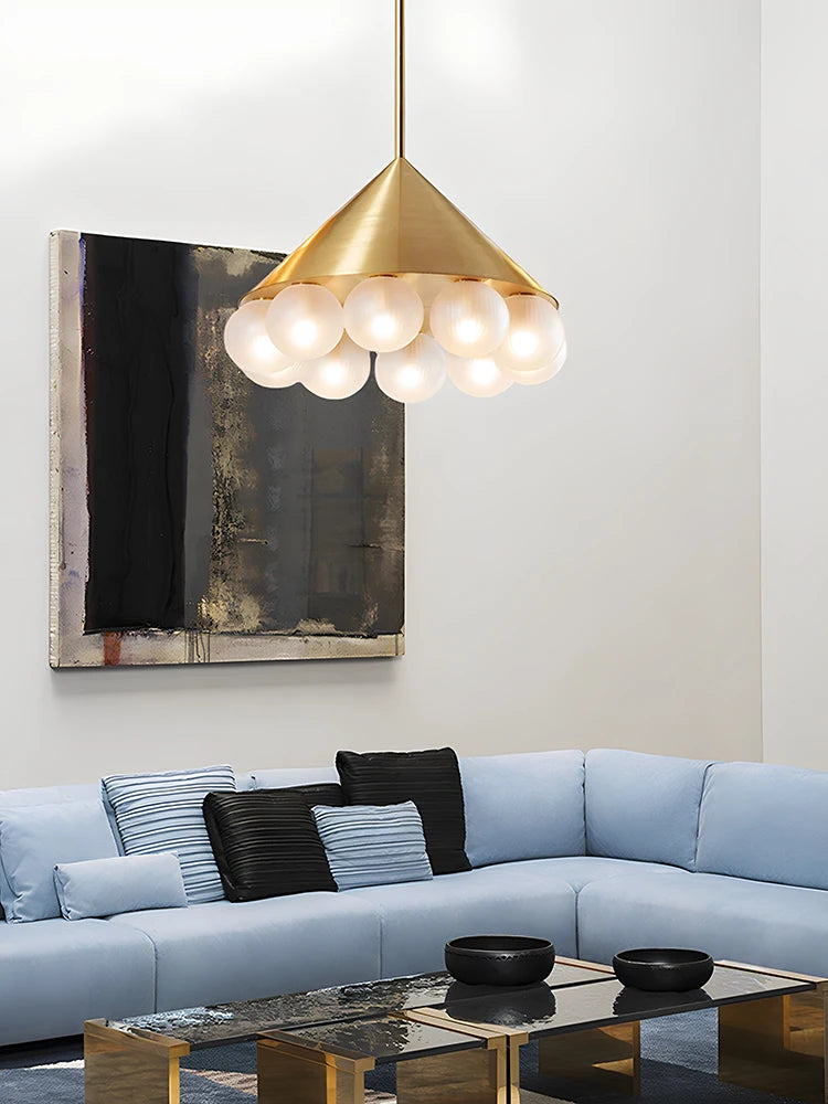 Modern living room with a gold pendant light, light blue sofa, and abstract painting.