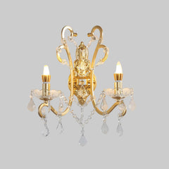 Decorative wall lamp with gold finish and crystal details on a gray background