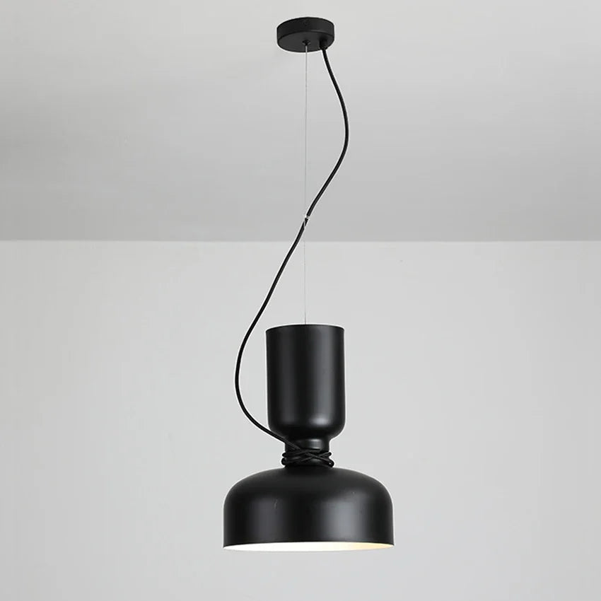 A matte black dome pendant light hanging from a black ceiling mount with a contrasting cord detail.