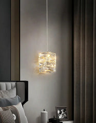 Modern pendant light fixture in a bedroom setting with neutral decor.