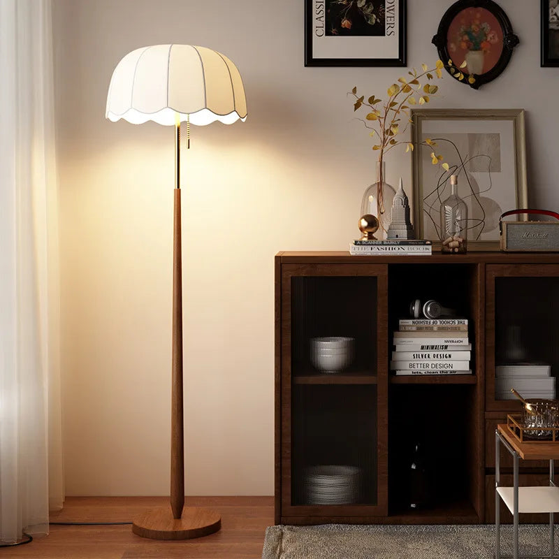 Floor lamp next to a wooden cabinet with decorative items in a room.
