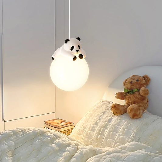 White globe pendant light with a white panda figurine resting on top, hanging in a child's bedroom.