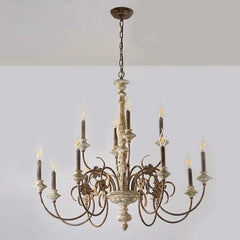 Close-up view of the distressed wood finish and floral detailing on a candle chandelier