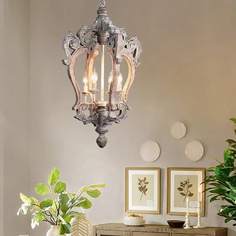 Decorative chandelier hanging in a room with plants and wall art.