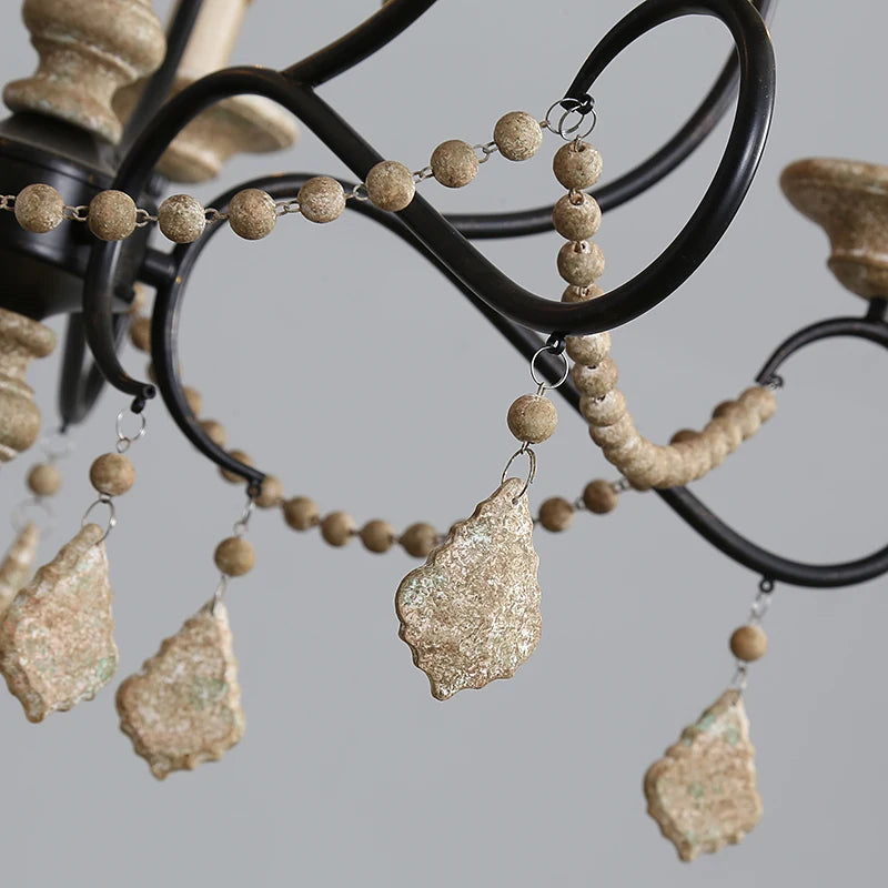 Detailed view of the chandelier arms, showing the connection points for wood bead strands and crystal droplets.