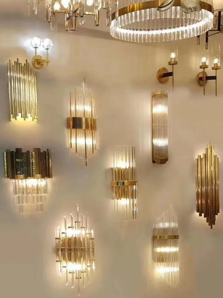 Collection of gold wall sconces and chandelier on a white wall