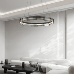 Modern chandelier hanging in a living room with a white sofa and coffee table.