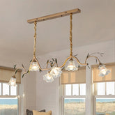 Gold floral pendant light with five glass shades, suspended by braided ropes from a wooden bar.