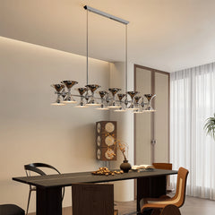 Chrome cluster chandelier with horn-shaped shades hanging over a dining table