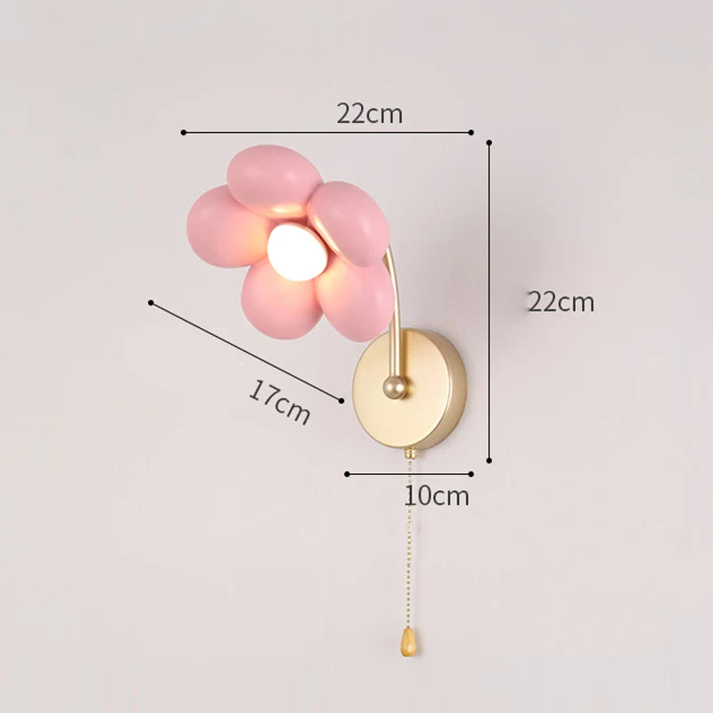 Wall lamp with pink floral design and gold fixture, showing dimensions on a light gray background.