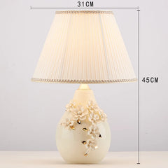 Decorative table lamp with floral design on a white background