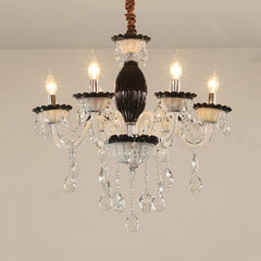 Close-up of a black and crystal candelabra chandelier with five illuminated candle-style bulbs and cascading teardrop crystals.