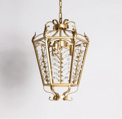 Decorative gold pendant light with intricate design on a white background