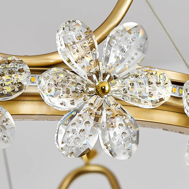 Close-up of a decorative light fixture with crystal-like flowers and gold accents.