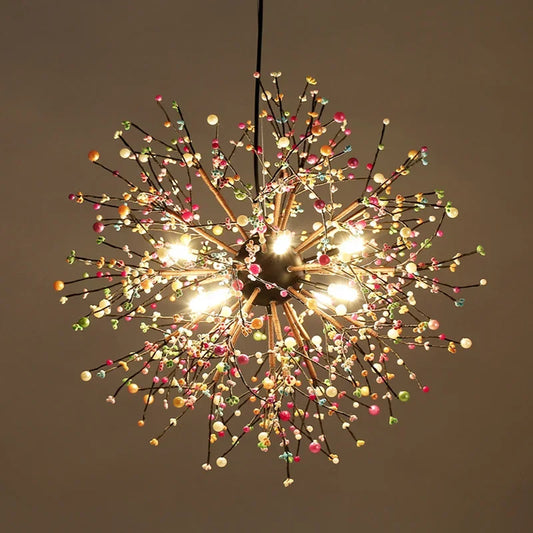 Close-up view of a colorful pearl and iron dandelion starburst pendant light against a dark background.