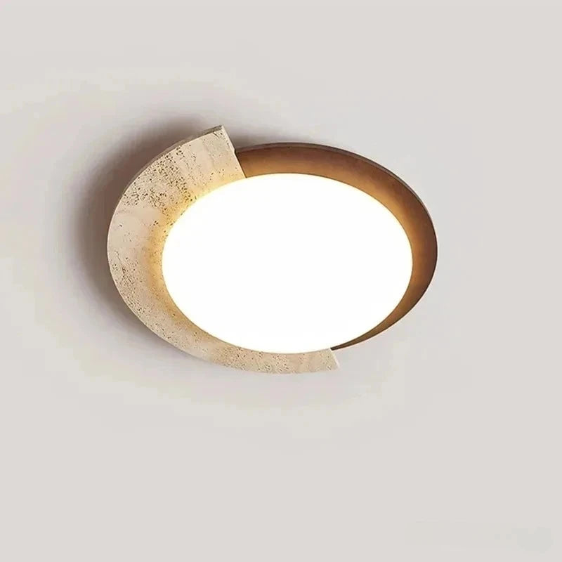 Top-down view of a unique oval flush mount light fixture showcasing its stone texture and circular warm LED.