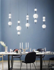 Modern dining room with white pendant lights against a blue wall.
