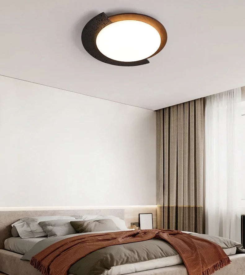 Ceiling light fixture in a bedroom setting with a bed and curtains.