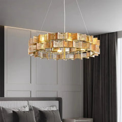 A bedroom with a gold ring chandelier adorned with amber faceted glass crystals.