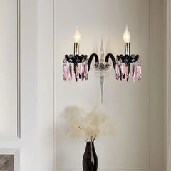 A close-up of a two-light wall sconce with multi-colored crystal accents, matching the chandelier design.