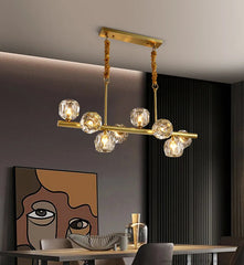 Modern chandelier with glass bulbs in a dining room setting.