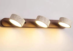 Three-light fixture with concrete-like finish on a neutral background