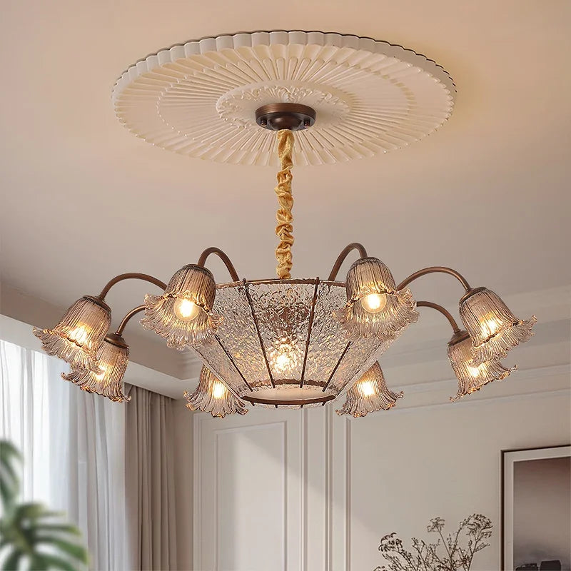Close-up of the bronze floral glass shade chandelier with light on.