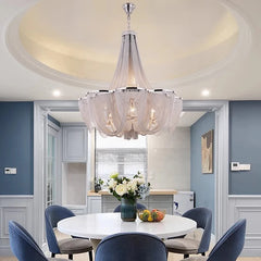 Dining room with a chandelier, table, and chairs.