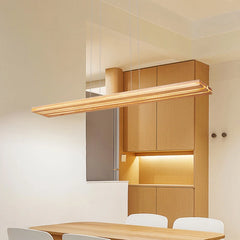 Modern kitchen with wooden cabinets and a light fixture.