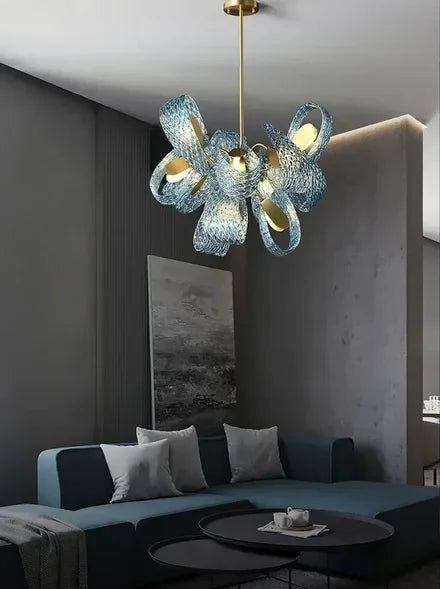 Modern chandelier hanging above a living room with a sofa and coffee table.