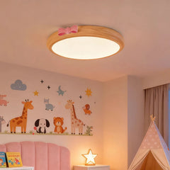 A round, flush mount ceiling light with a wood-tone frame and a pink bow accent, installed in a child's bedroom decorated with animal wall decals, near a pink bed and a tent.