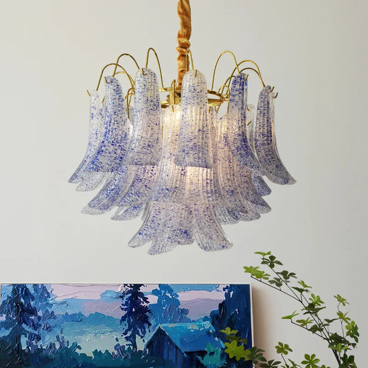 Gold chandelier with cascading bell-shaped glass elements speckled with blue and white, hanging from a rope.