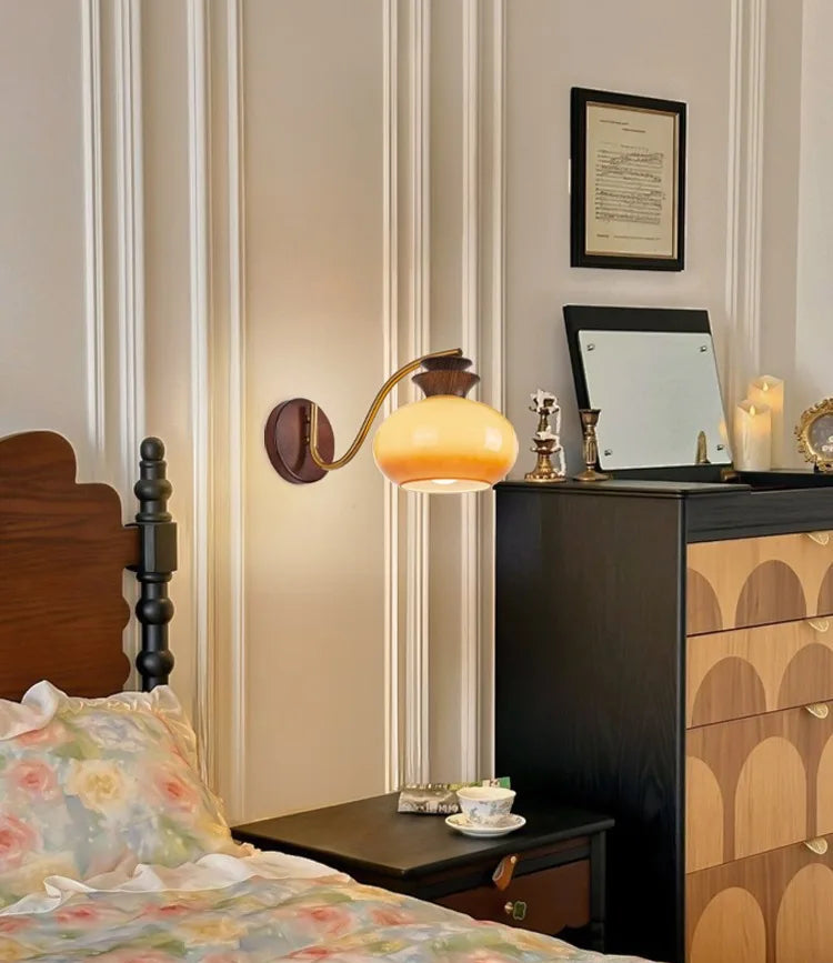 Bedroom interior with a nightstand, lamp, and dresser.