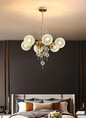 Modern chandelier hanging above a bed with a dark wall background