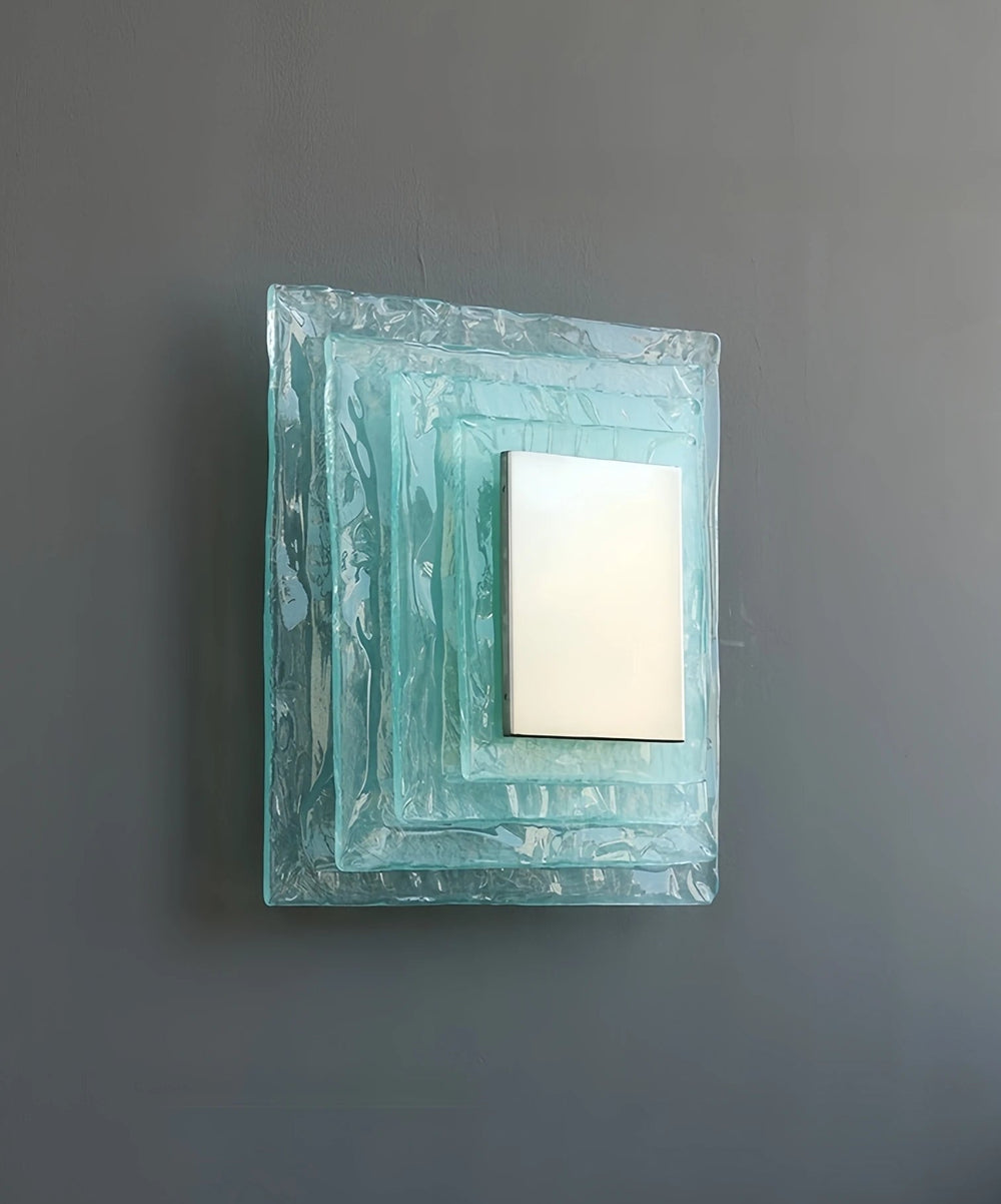 Square wall mirror with decorative frame on a gray wall
