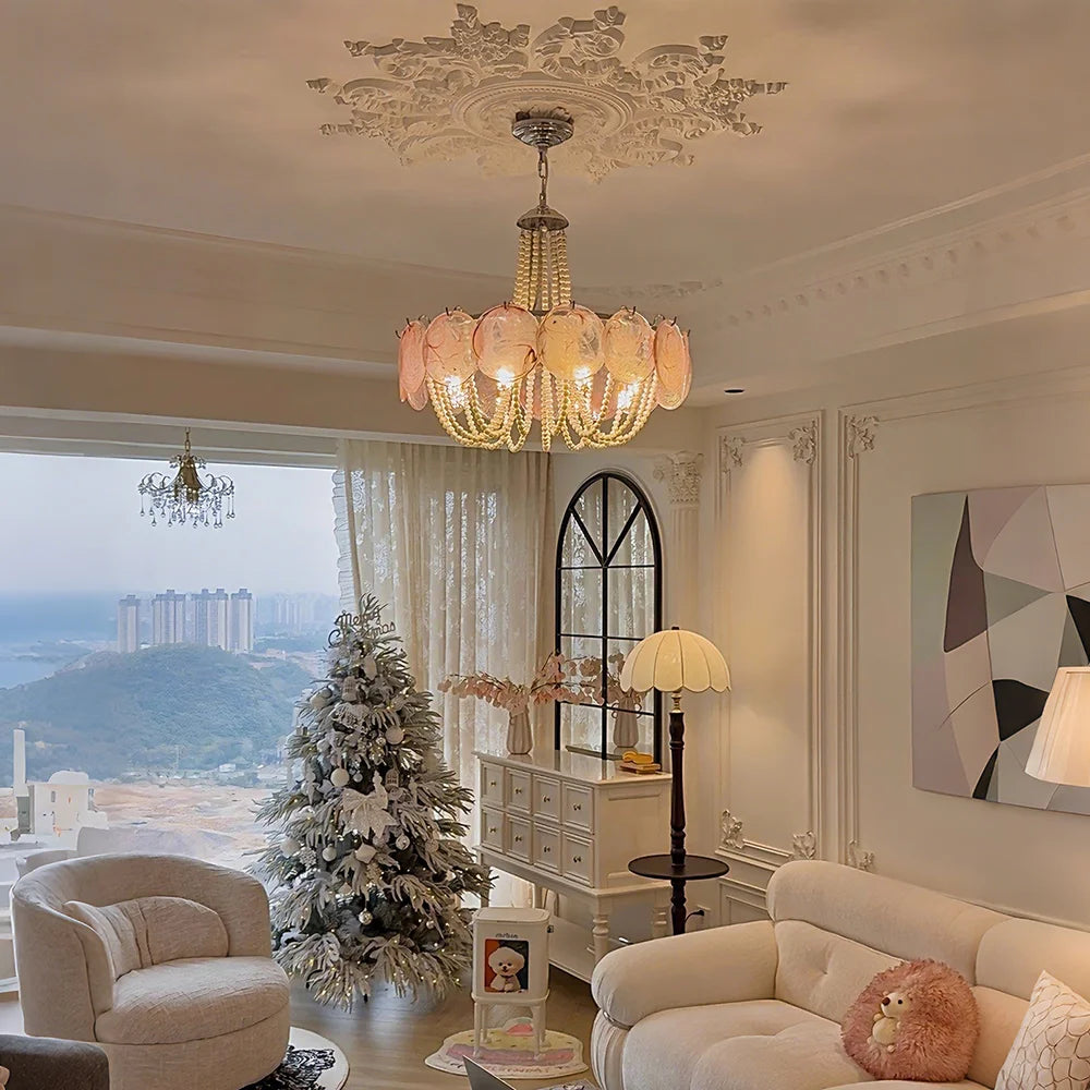 A festive living room scene with a gold beaded chandelier and a decorated Christmas tree.