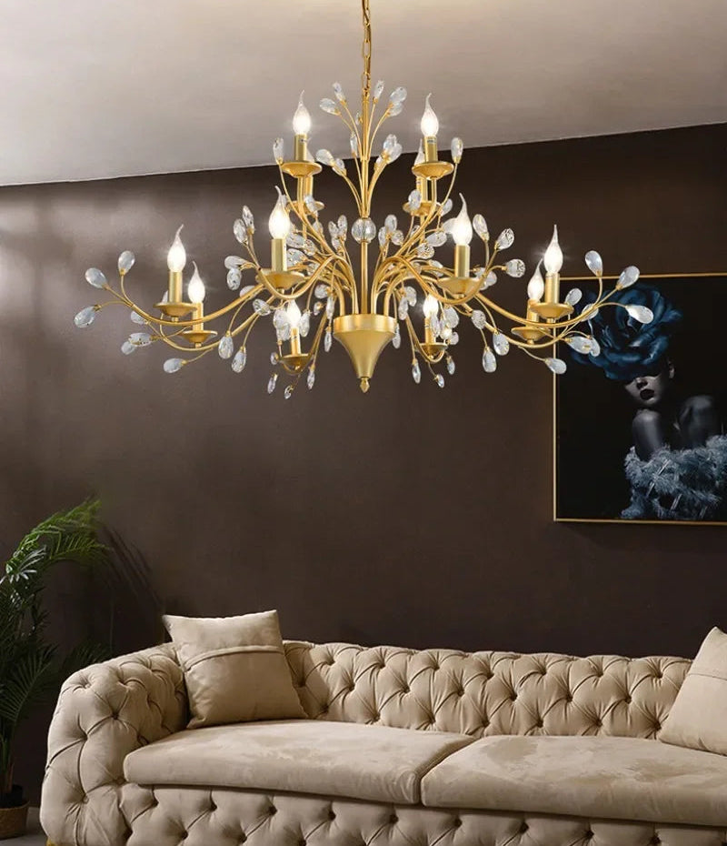 Gold chandelier hanging above a beige sofa in a living room setting.