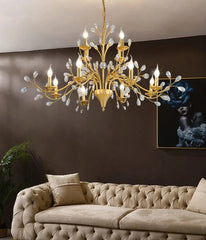Gold chandelier hanging above a beige sofa in a living room setting.